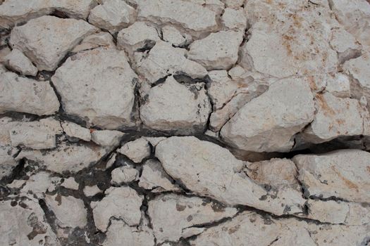 beige background natural stone with cracks and holes macro view