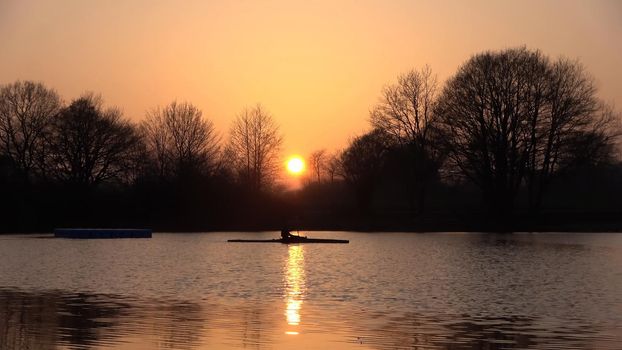 A rower on a lake in a dream sunset
