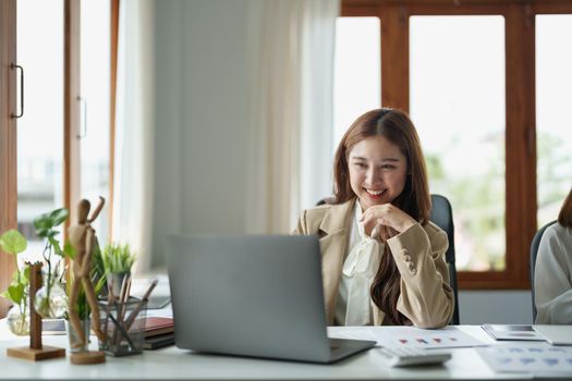 Portrait of charming young businesswoman working with laptop computer for financial on laptop in boardroom.