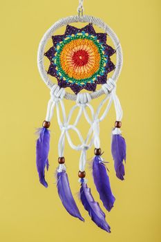 Amulet Dreamcatcher on a yellow background close-up protecting the sleeper from evil spirits and diseases