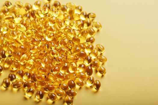 The texture of the capsules in the shell with liquid vitamin D3 in full screen. Gold capsules with a dietary supplement for joints teeth and bones.