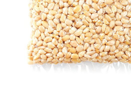 Kernels of peeled pine nuts in vacuum packaging on a white background with free space