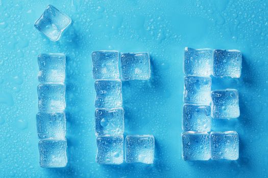 The inscription ICE made of ice cubes on a blue background