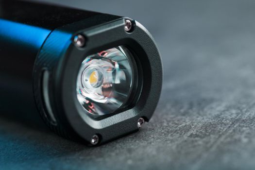 Black Rechargeable Flashlight handheld, LED close-up on a black background