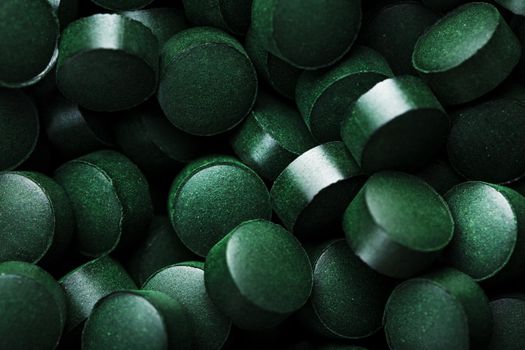 Green tablets from spirulina vegetarian dietary supplement as a full-screen texture