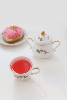 morning breakfast with colorful pink drink and donuts on white table. holiday, birthday party composition, flatlay top view. 