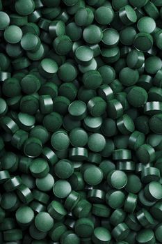 Green tablets from spirulina vegetarian dietary supplement as a full-screen texture