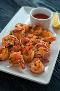 Fried shrimps with greens salt lemon and sauce on the plate