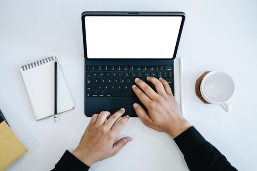 Young man using work from home tablet at work, the blank space on the computer screen can insert text