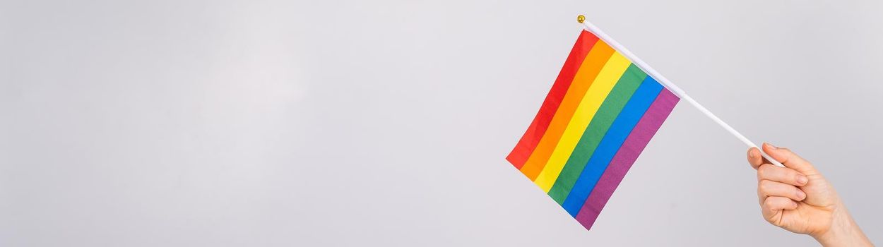 A woman is holding a rainbow flag on a white background