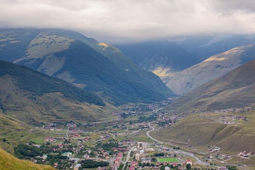 Mountain landscape with a city at the bottom of the gorge. Upper Fiagdon in North Ossetia.