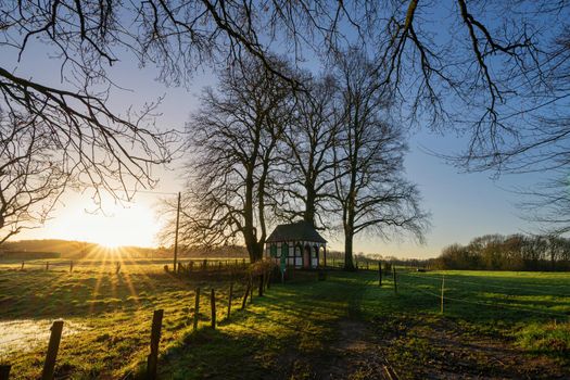 Panoramic image of small chapel under trees during sunrise, Bergisch Gladbach, Germany