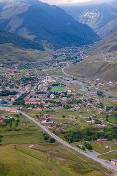Mountain landscape with a city at the bottom of the gorge. Upper Fiagdon in North Ossetia.