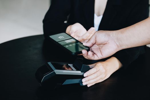 Payment security technology concept and service fees, Employees are holding electronic card machines for customers to use smartphone mobile to pay via paywave technology