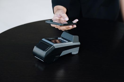 Secure payment technology concept and service charge, customers are using their phone to pay using paywave technology by tapping near the electronic card terminal