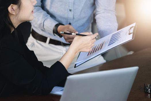 Teamwork concept, consultation, female advisor pointing to budget, finance and investment papers, discussing and planning finances with male economists in conference room