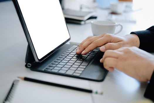 Young man using work from home tablet at work, the blank space on the computer screen can insert text