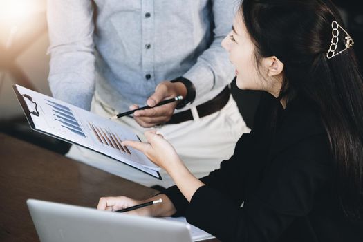 Teamwork concept, consultation, female advisor pointing to budget, finance and investment papers, discussing and planning finances with male economists in conference room