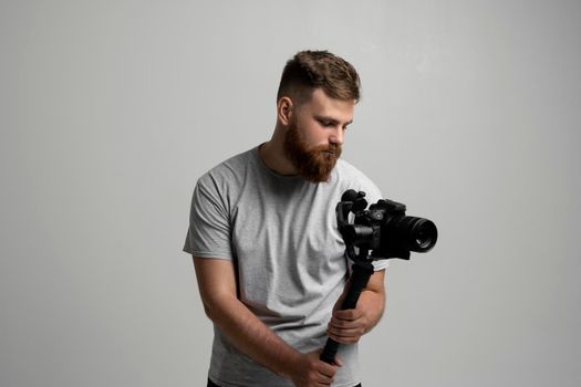 Bearder videographer filmmaker cinematographer dop with 3-axis gimbal and dslr camera. Filmmaking, videography, hobby and creativity concept