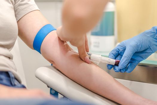Close-up Of Doctor Taking Blood Sample From Patient's Arm in Hospital for Medical Testing