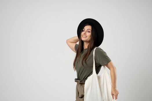 Woman with white cotton bag in her hands. Girl holding textile grocery bag with vegetables. Zero waste concept