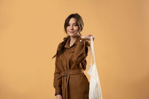 Woman with white cotton bag in her hands. Girl holding textile grocery bag with vegetables. Zero waste concept