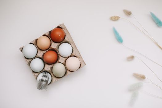 Chicken eggs of natural shades and colors on a white background. Healthy organic food, natural farmer's products concept. Happy Easter background. Selective focus. 
