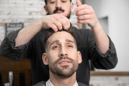 Barber shop. Man in barber's chair, hairdresser styling his hair. High quality photography