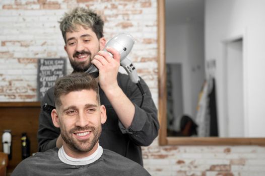 Barber drying hair of customer. High quality photo