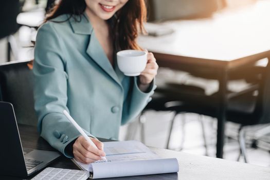 Young economists or accountants or financiers and investors are reviewing budget documents and using computers to study impact and risk assessments on corporate investment management