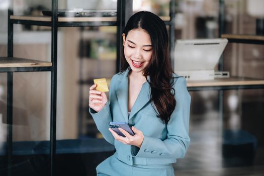 Online Shopping and Internet Payments, Beautiful Asian women are using their credit cards and mobile phones to shop online or conduct errands in the digital world