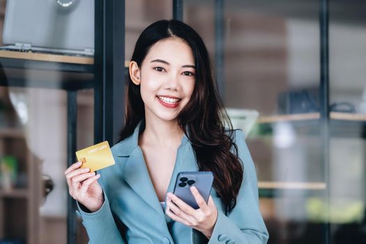 Online Shopping and Internet Payments, Beautiful Asian women are using their credit cards and mobile phones to shop online or conduct errands in the digital world