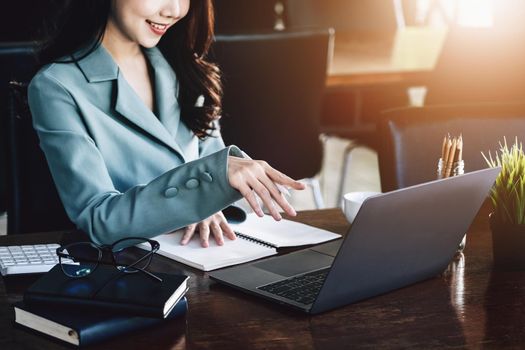 Finance and Investment Concepts, Female entrepreneurs are holding pen to start analyzing financial statements to increase investment by using computers and notebooks to work