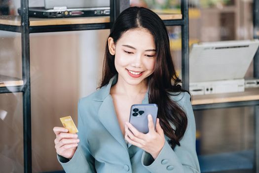 Online Shopping and Internet Payments, Beautiful Asian women are using their mobile phones and credit cards to shop online or conduct errands in the digital world