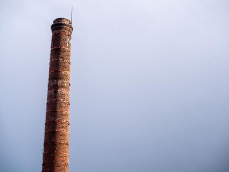 Old bricks factory chimney with bricks. blue sky background.