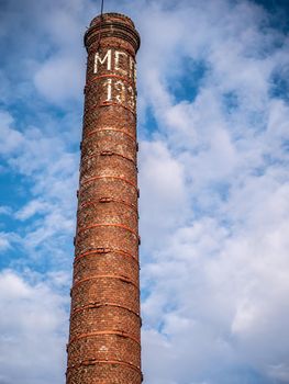 Old bricks factory chimney with bricks. blue sky background.