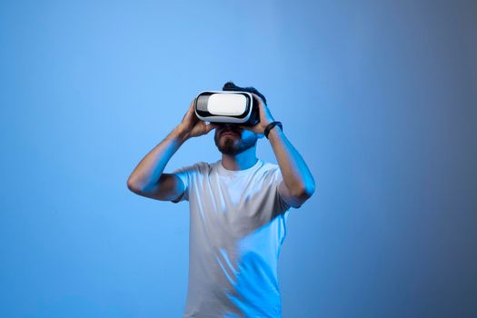 Young bearded man with VR glasses playing a video games in virtual reality