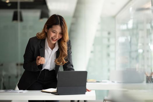 Portrait attractive young asian business woman using digital tablet celebrate success or happy pose