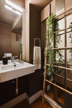 A lovely dark bathroom with a square sink and a flower