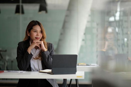 Portrait of charming young businesswoman working for financial on laptop in boardroom