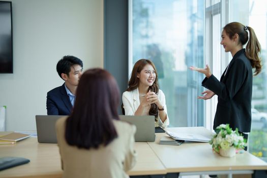 Group of asian business meeting and discussing with new startup idea project. Creative business people planning strategy analysis and brainstorm with document report in office.