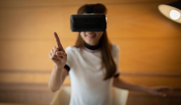 young asian woman touching the air during the VR experience.