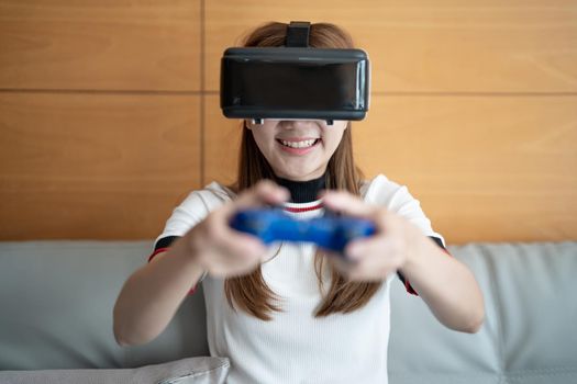 close up happy emotion asian woman playing video games with controller on abstract background toned with virtual glasses.