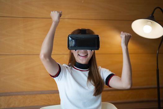 Photo of young asian woman cheerful guy have fun celebrate victory win game goggles ay her home.