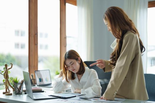 Young business woman feeling be serious, holding her head while her boss is complaining about the work