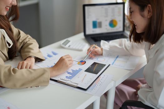 Two asian business woman are meeting for analysis data figures to plan business strategies. Business discussing concept.