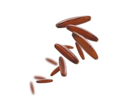 Raw brown rice levitates on a white background.