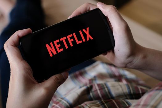 CHIANG MAI, THAILAND, MAR 29, 2020: Woman hand holding Smart Phone with Netflix logo on Apple iPhone Xs at home. Netflix is a global provider of streaming movies and TV series.