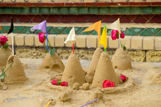 Group of sand pagoda on temple in Songkran Festival, Sand Pagoda is an ancient tradition of the ancient people. And these sand pagodas are also decorated with flags and flowers