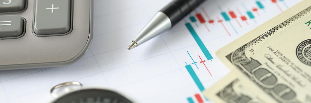 Close-up of stock market candlestick chart, compass and money cash. Buy and sell indicators for trade. Financial diagram with assets values moving up and down. Business planning and direction concept